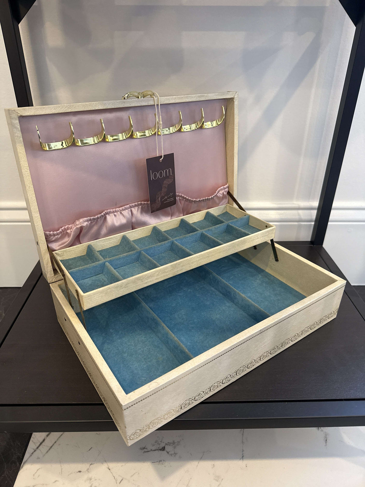 Mele ivory jewelry box open, showing pink satin lid with necklace hooks and blue velvet lift-out tray