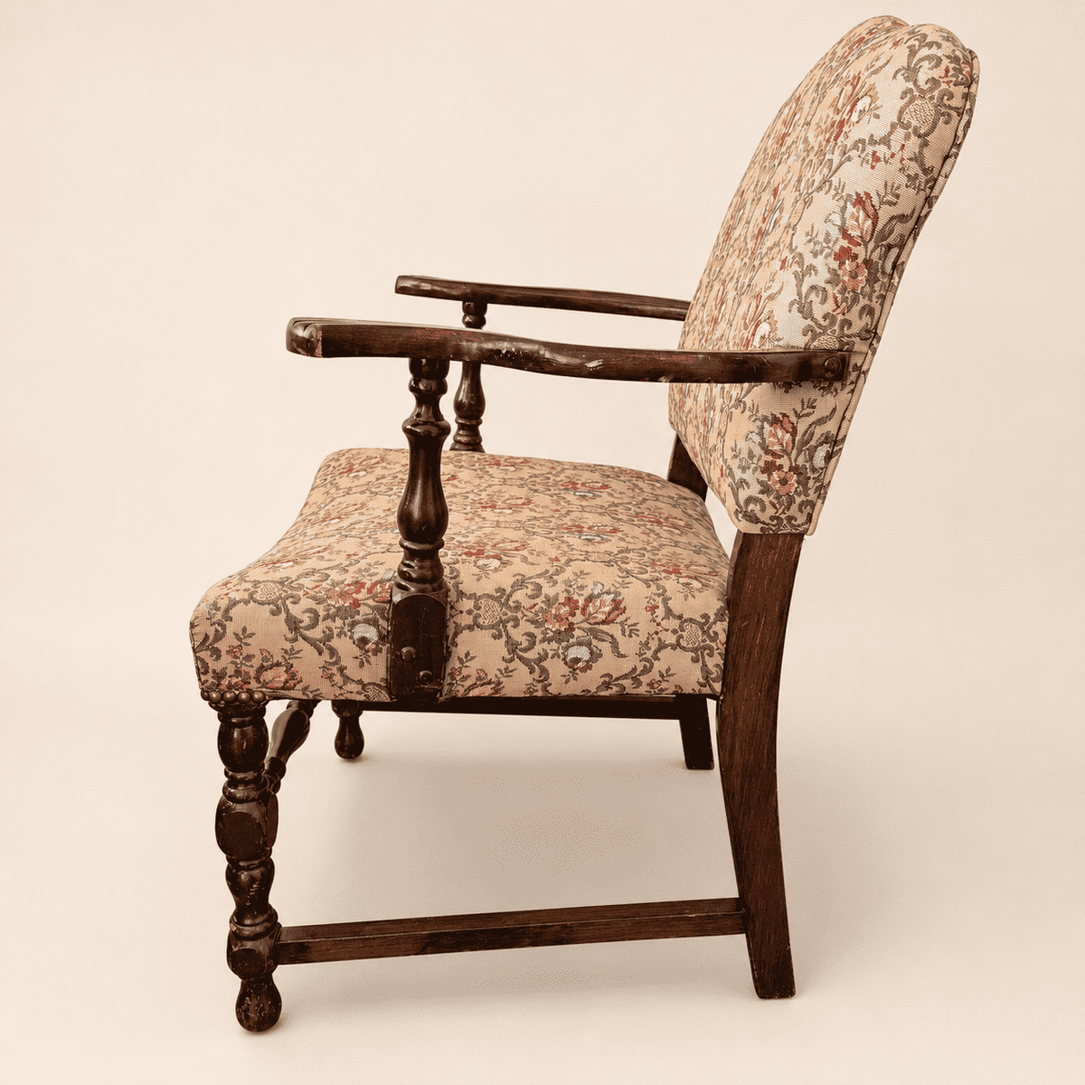 Floral tapestry seat and brass nailhead trim on the antique armchair