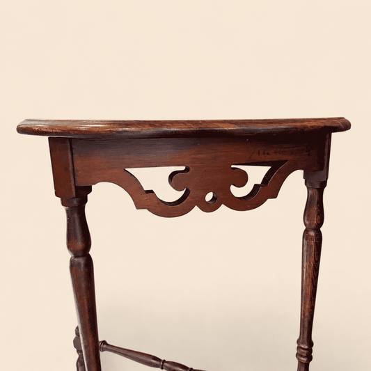Close-up of the pierced fretwork apron on the antique mahogany demilune console table
