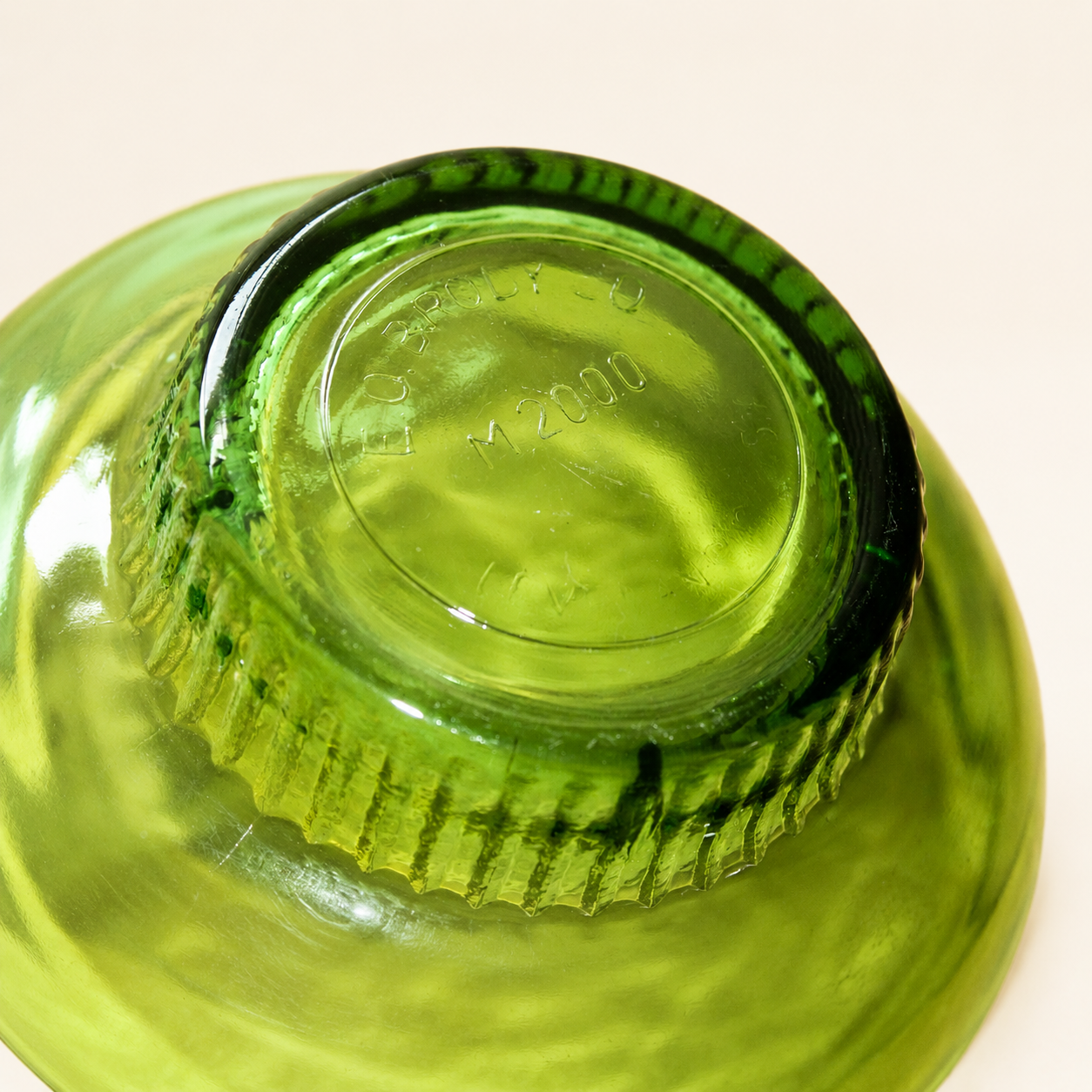 Base of E.O. Brody green glass bowl showing the M2000 Cleveland maker's mark