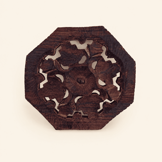 Hand-carved octagonal wood trivet with pierced floral openwork center, front view