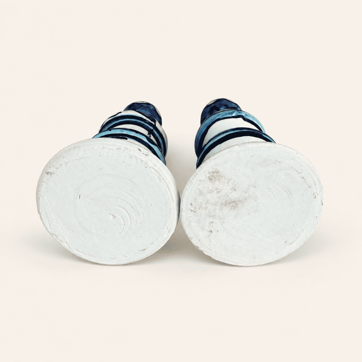 Unglazed white bases of the pair of hand-painted ceramic candlesticks