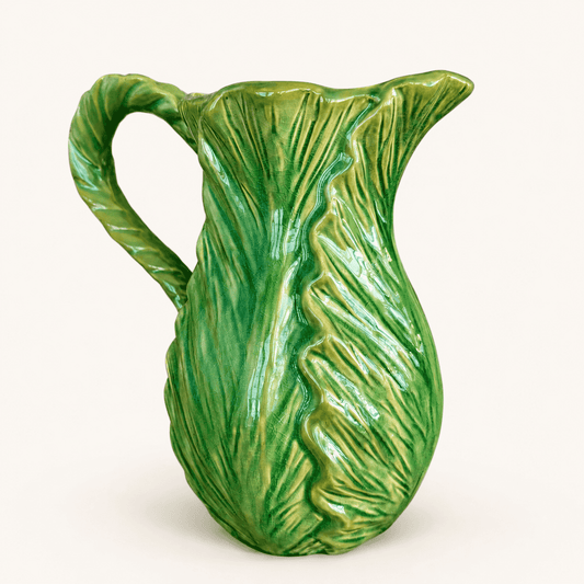Angled view of green cabbage leaf majolica pitcher showing molded leaves