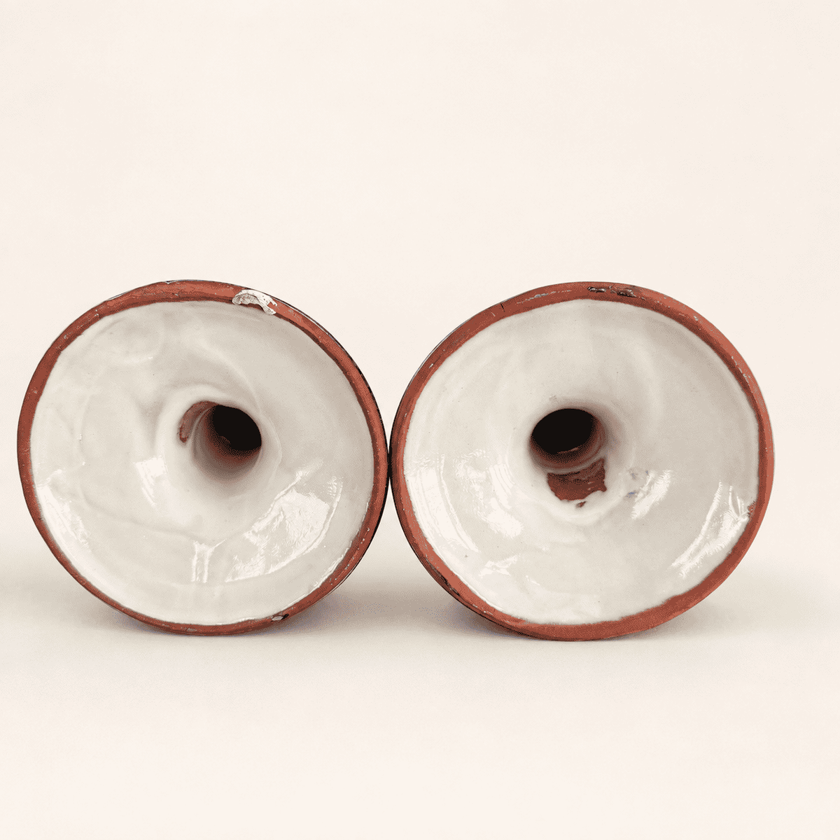 Underside of Talavera candlesticks showing red terracotta clay bases
