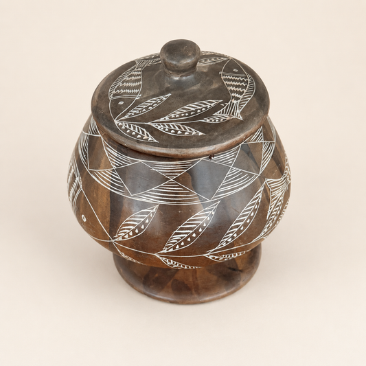 Top view of soapstone jar lid with etched fish and leaves