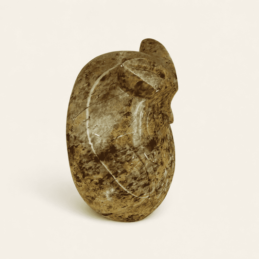 Angled view of carved stone owl figurine showing feather detail