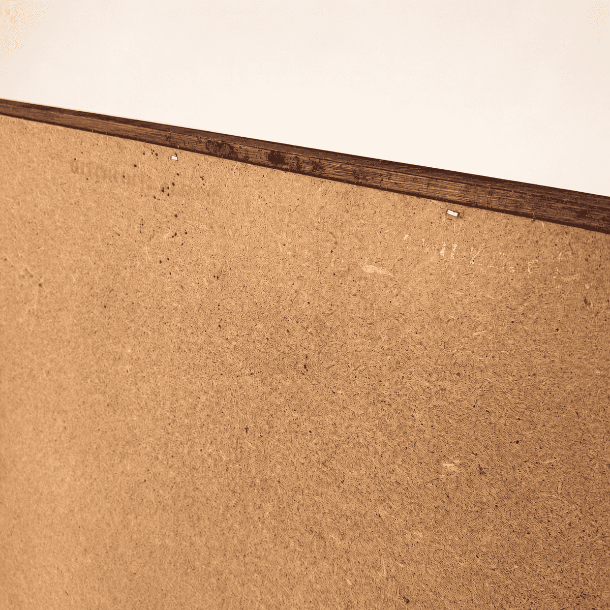 Edge detail of mirror back showing aged hardboard and staples