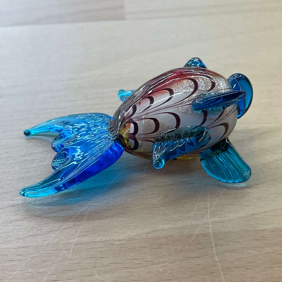 Art glass rainbow fish — top view of the colorful glass body