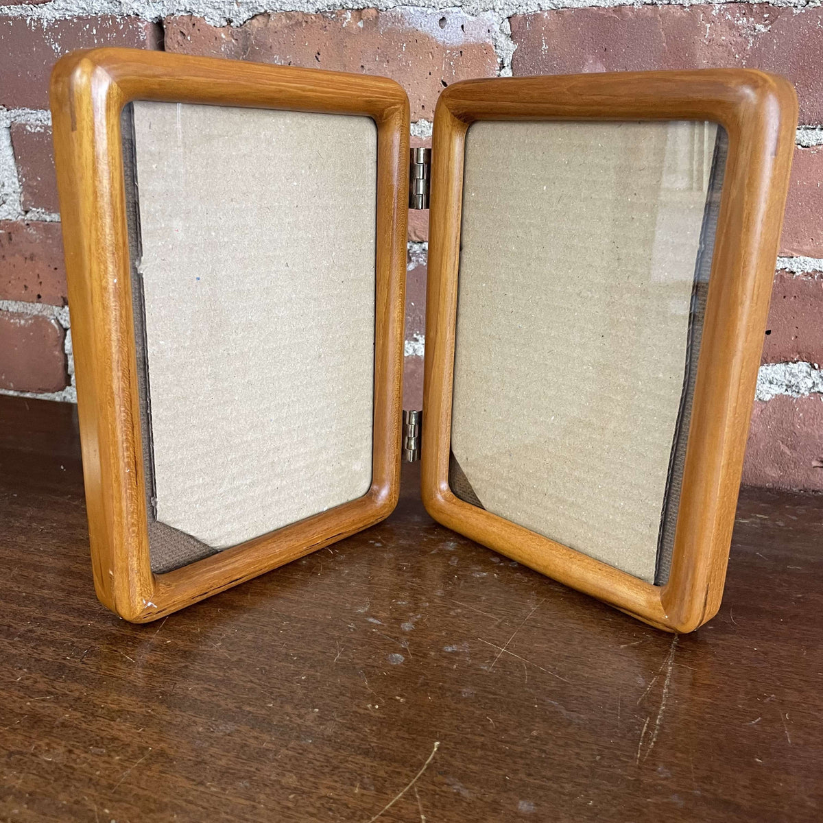 Vintage hinged double wood picture frame, open and standing with two portrait openings