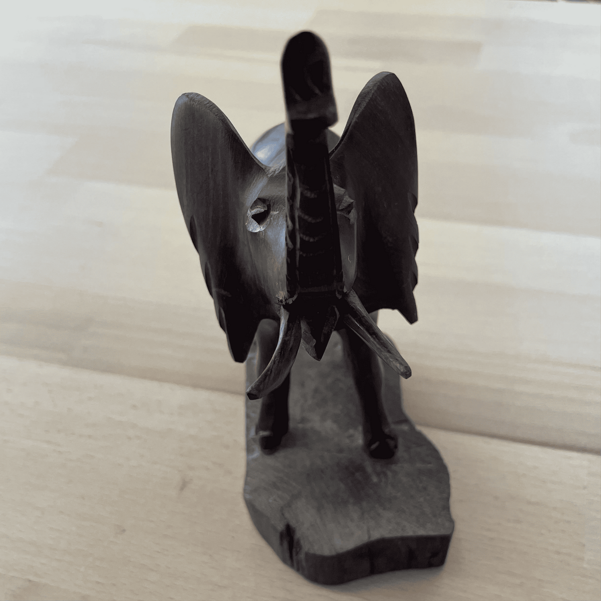 Carved wooden elephant — front view, ears spread