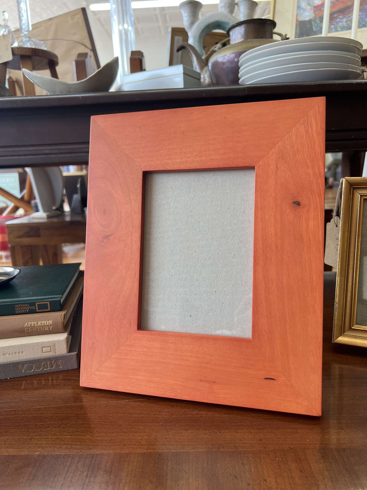 Vintage wide wood picture frame for a 5x7 photo, standing on a table