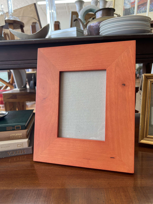 Vintage wide wood picture frame for a 5x7 photo, standing on a table
