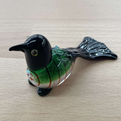 Art glass bird figurine in swirled green, blue and black with a long tail
