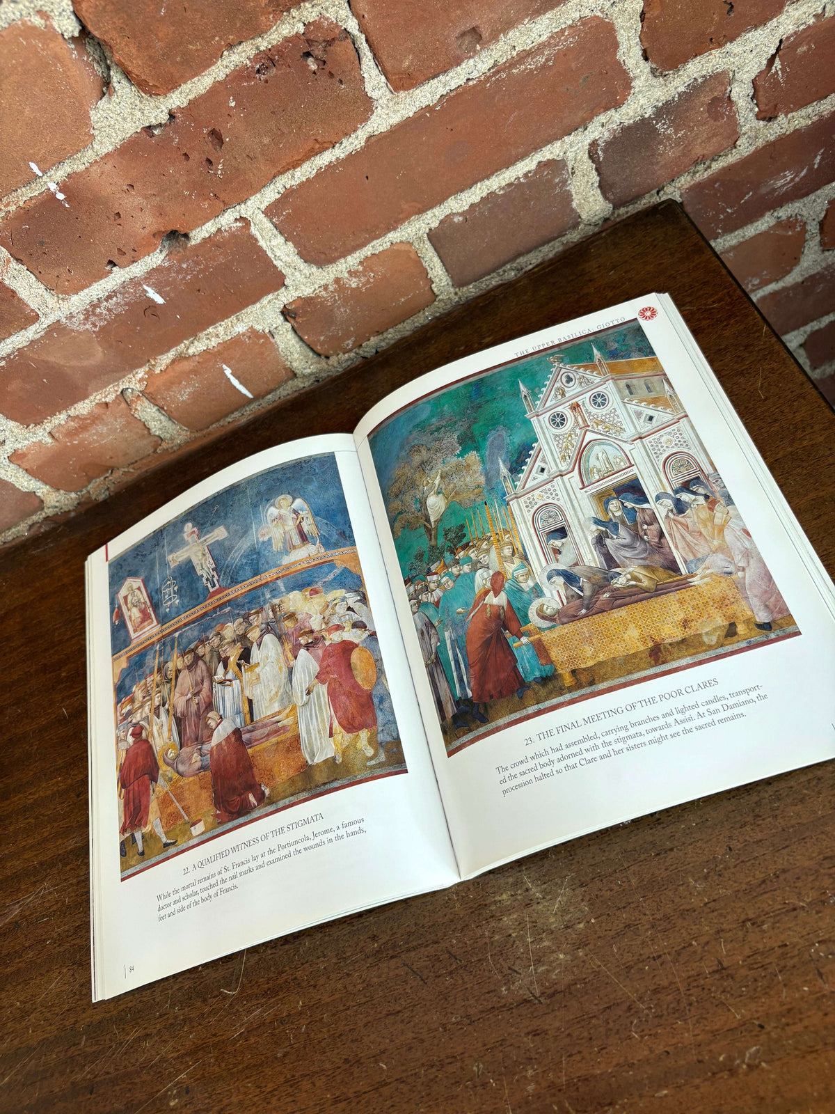 Assisi guidebook open to a fresco plate