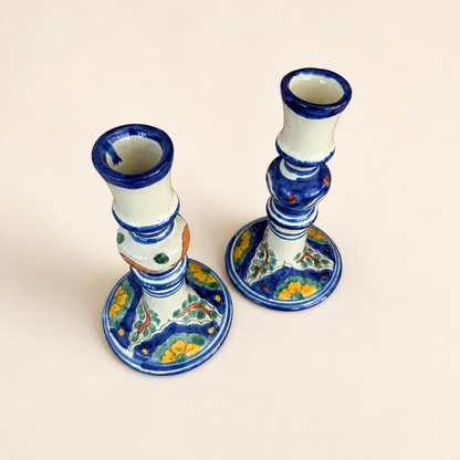 Angled top view of Talavera candlestick pair showing blue-rimmed candle cups