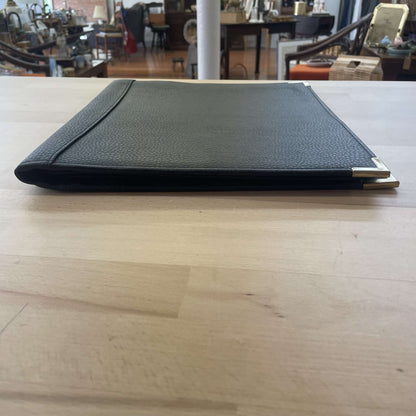 Black leather portfolio — open flat on a table