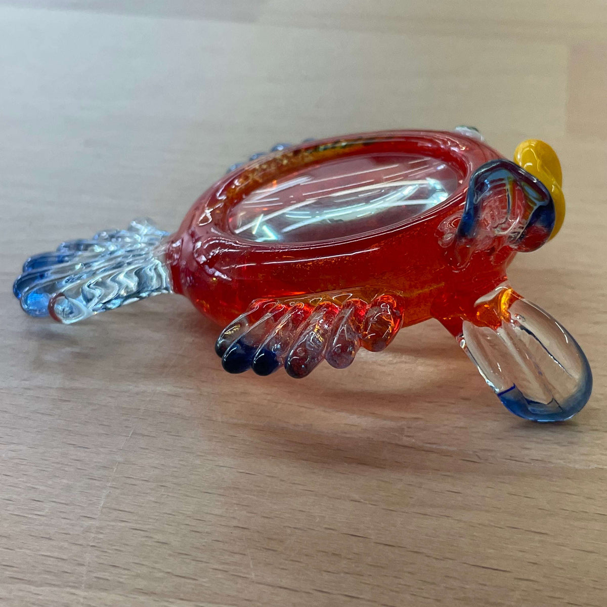 Art glass fish magnifier — overhead view of the orange glass body