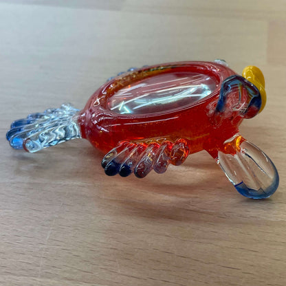 Art glass fish magnifier — overhead view of the orange glass body