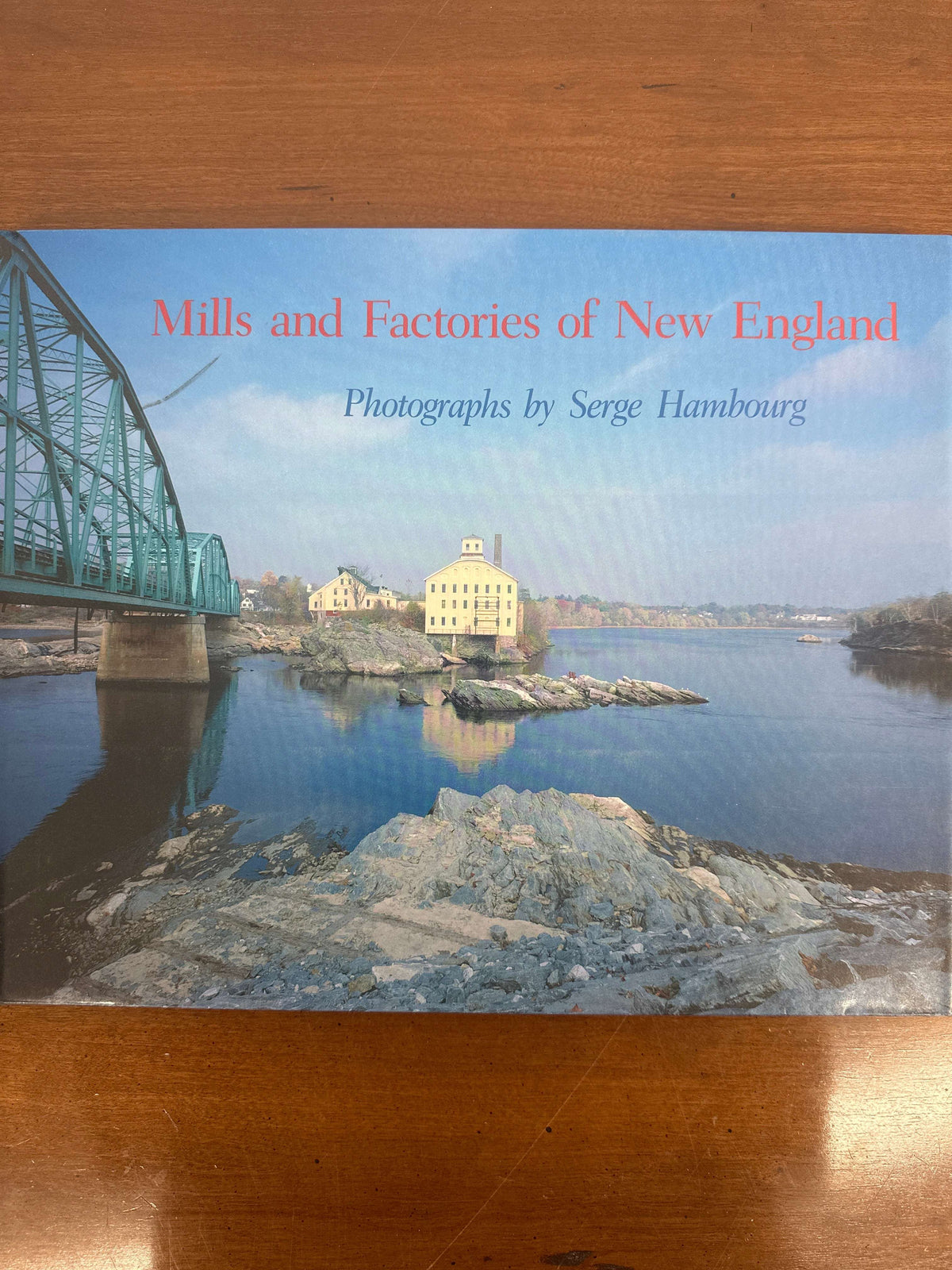 Cover of Mills and Factories of New England, showing a brick mill beside a river with a green truss bridge