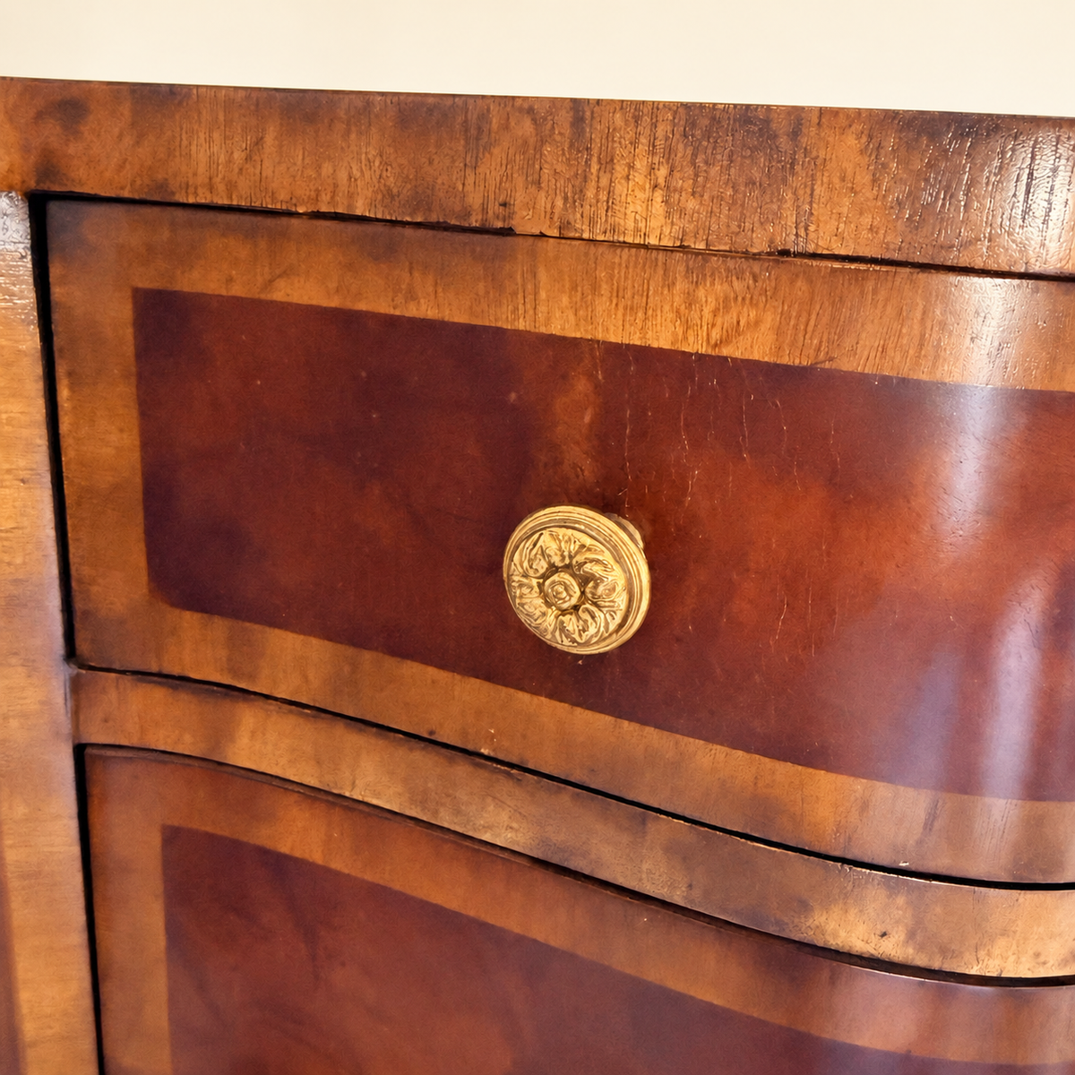 Small veneer chip to the base skirt near one leg, condition detail