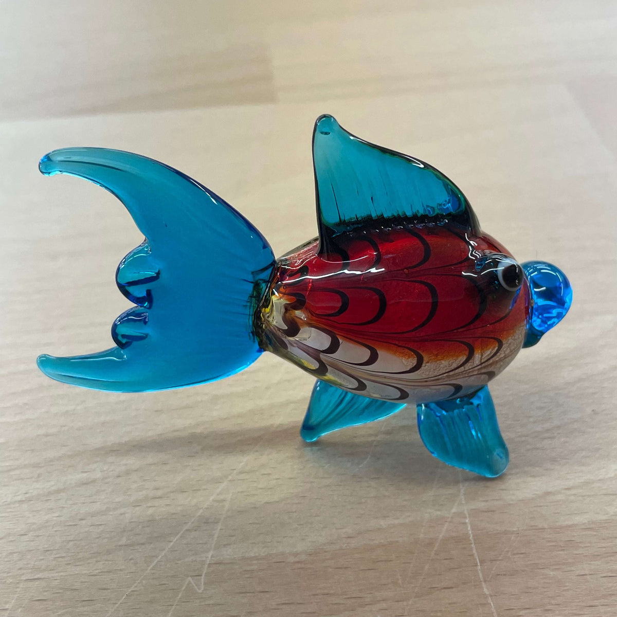Art glass rainbow fish — side view, blue tail and fins