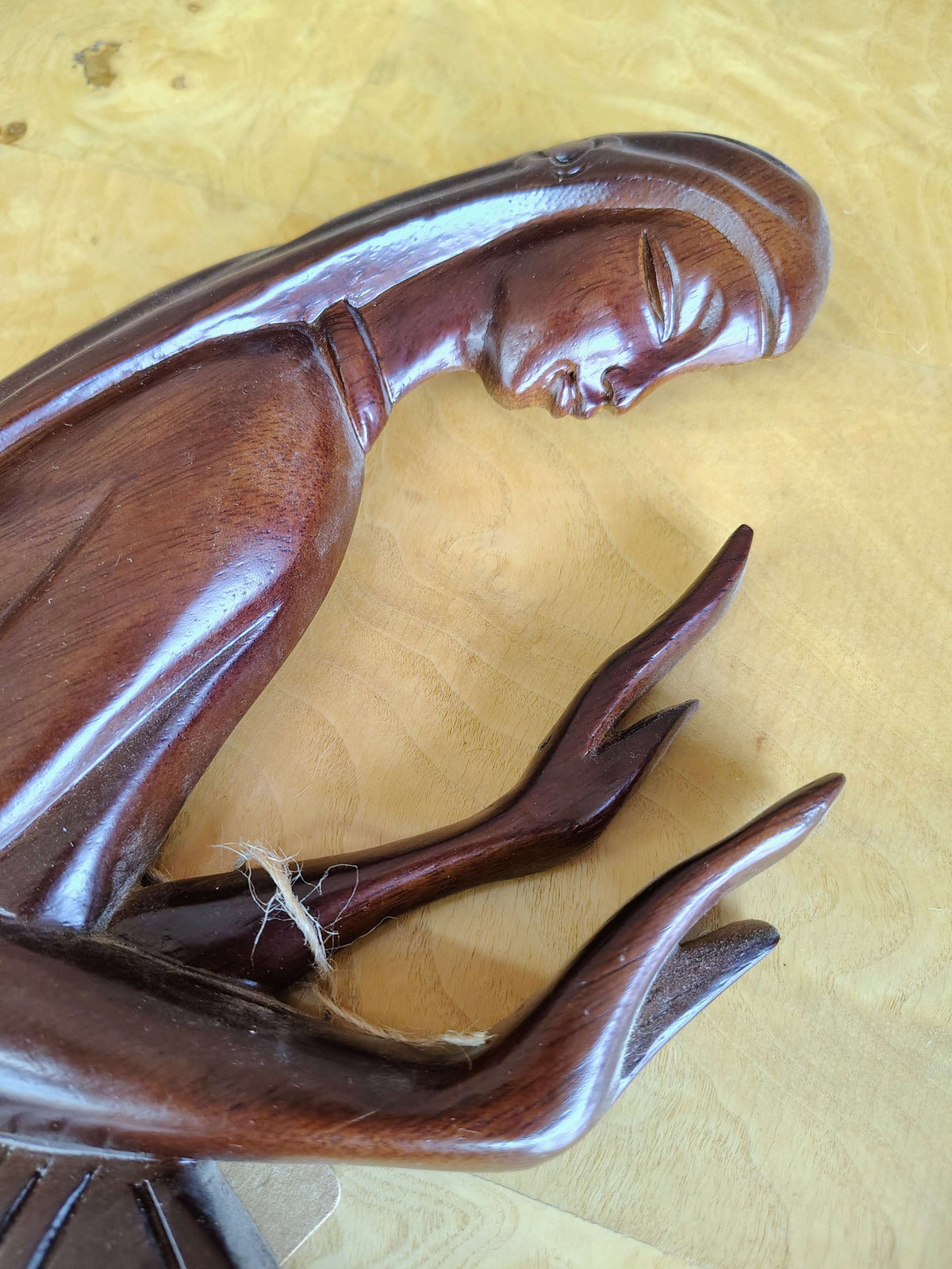Carved wood wall art — close-up of the face and hands