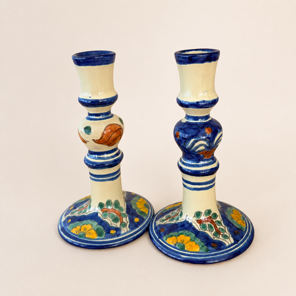 Three-quarter view of a pair of blue-and-floral Talavera candlesticks