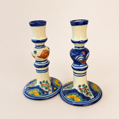 Three-quarter view of a pair of blue-and-floral Talavera candlesticks