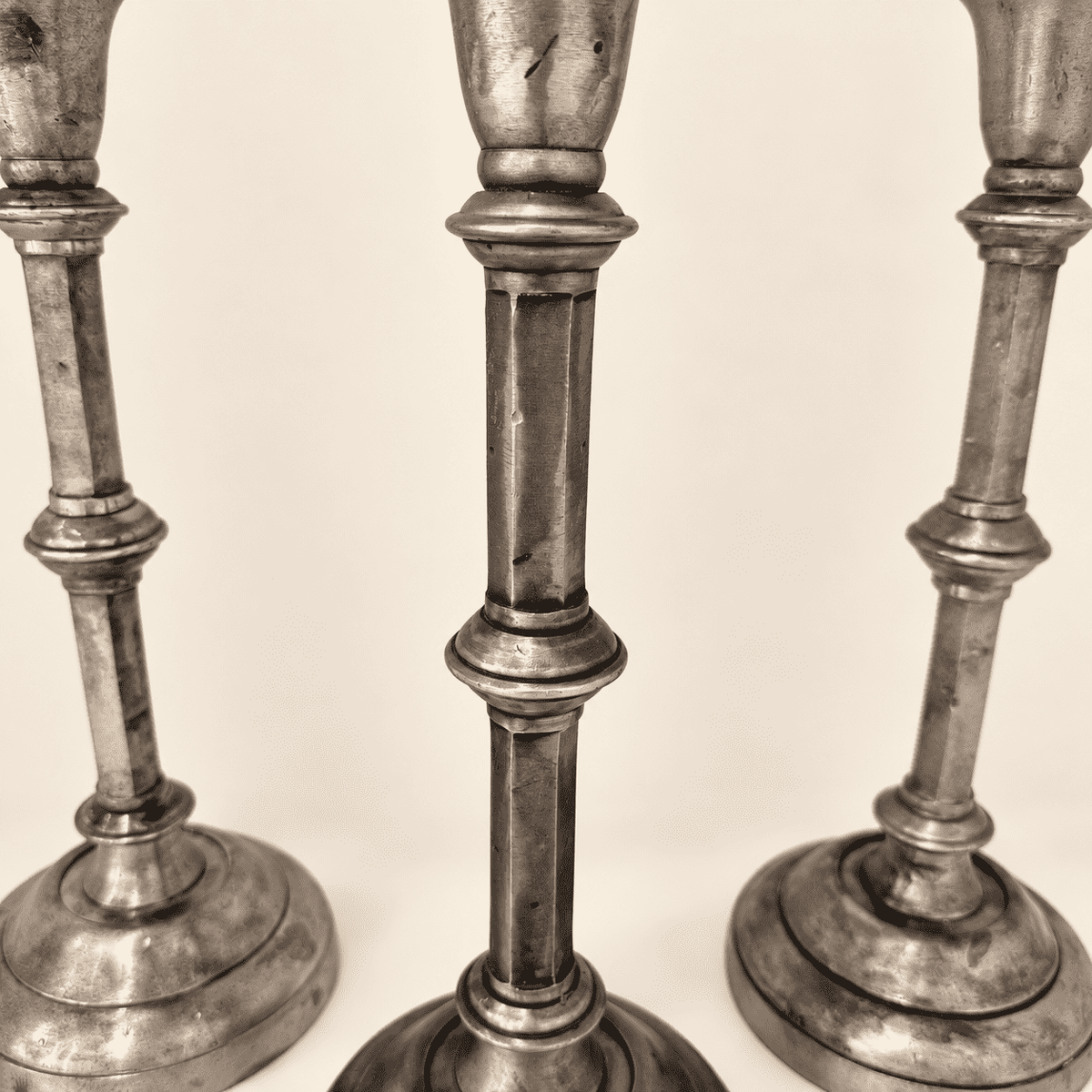 Faceted columns and turned knops of the three Anthropologie silver candlesticks