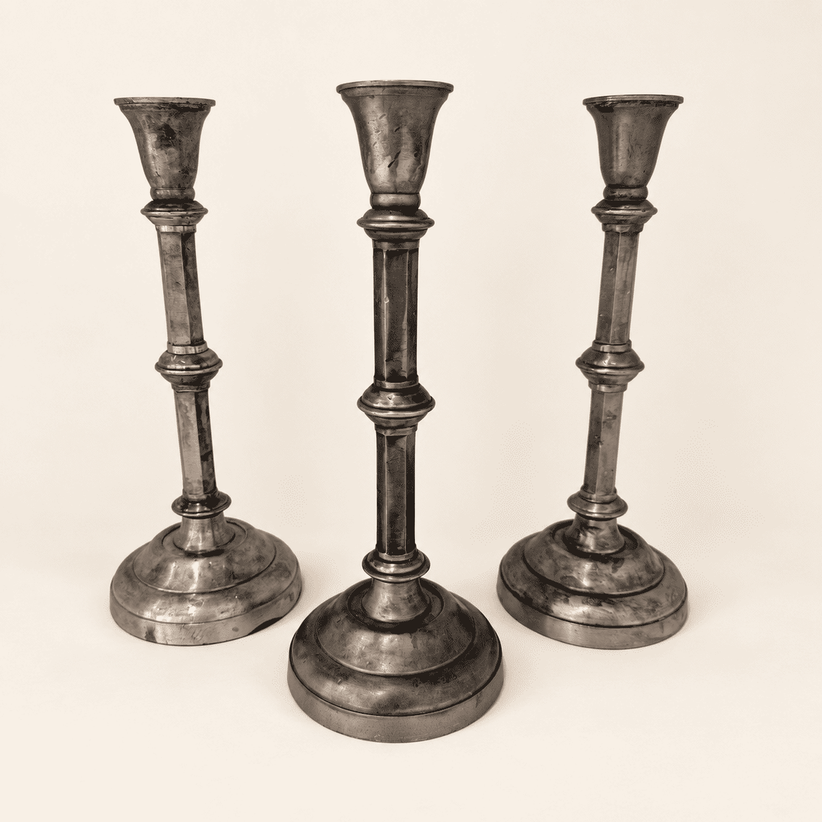 Set of three tall tarnished Anthropologie silver candlesticks, front view