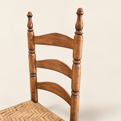 Ladder-back chair front view with three arched slats and acorn finials