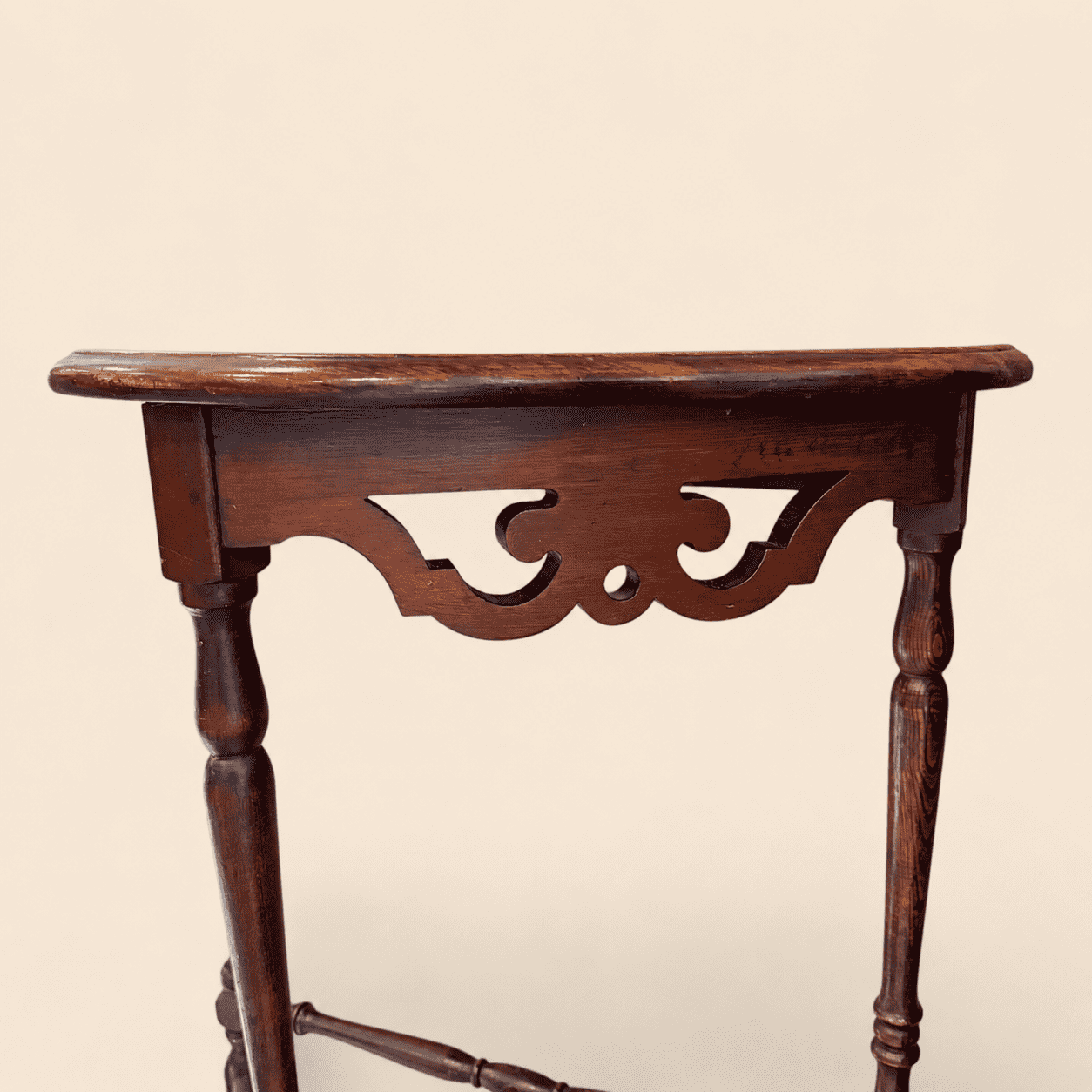 Close-up of the pierced fretwork apron on the antique mahogany demilune console table