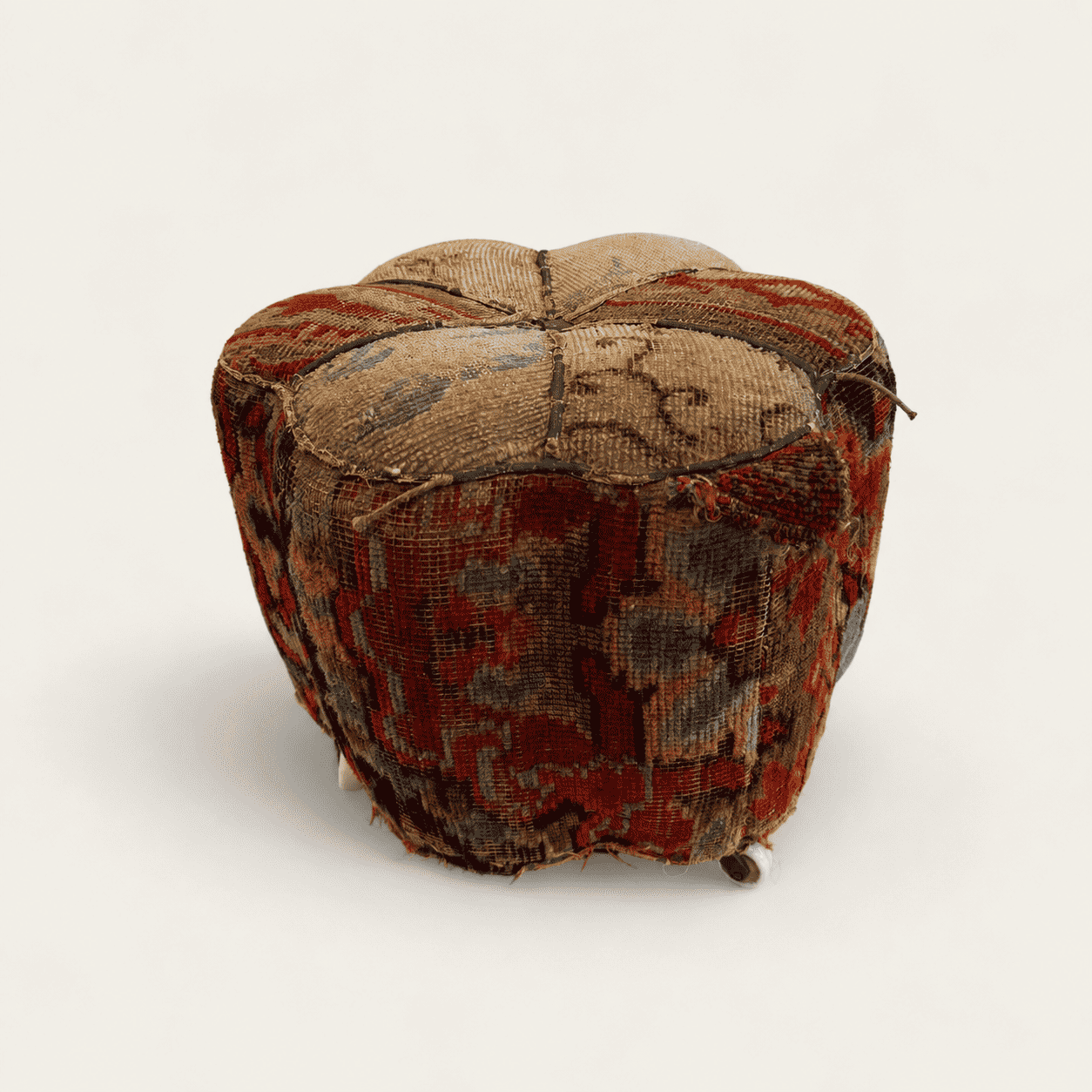 Antique Oriental carpet footstool with hand-knotted rug covering on porcelain casters, front view