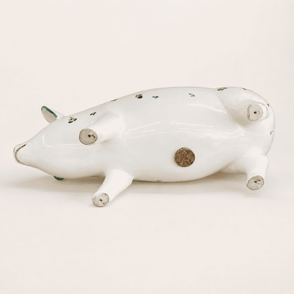 Large hand-painted pig bank on its side showing cork belly stopper and unglazed feet