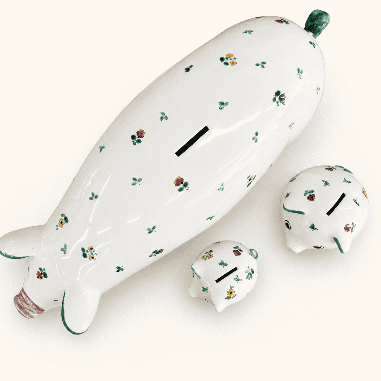 Flat-lay of three Austrian floral piggy banks with coin slots, graduated sizes