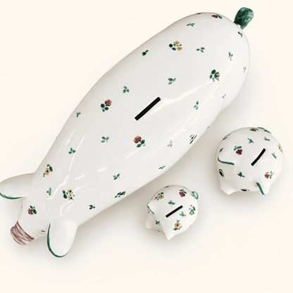 Flat-lay of three Austrian floral piggy banks with coin slots, graduated sizes