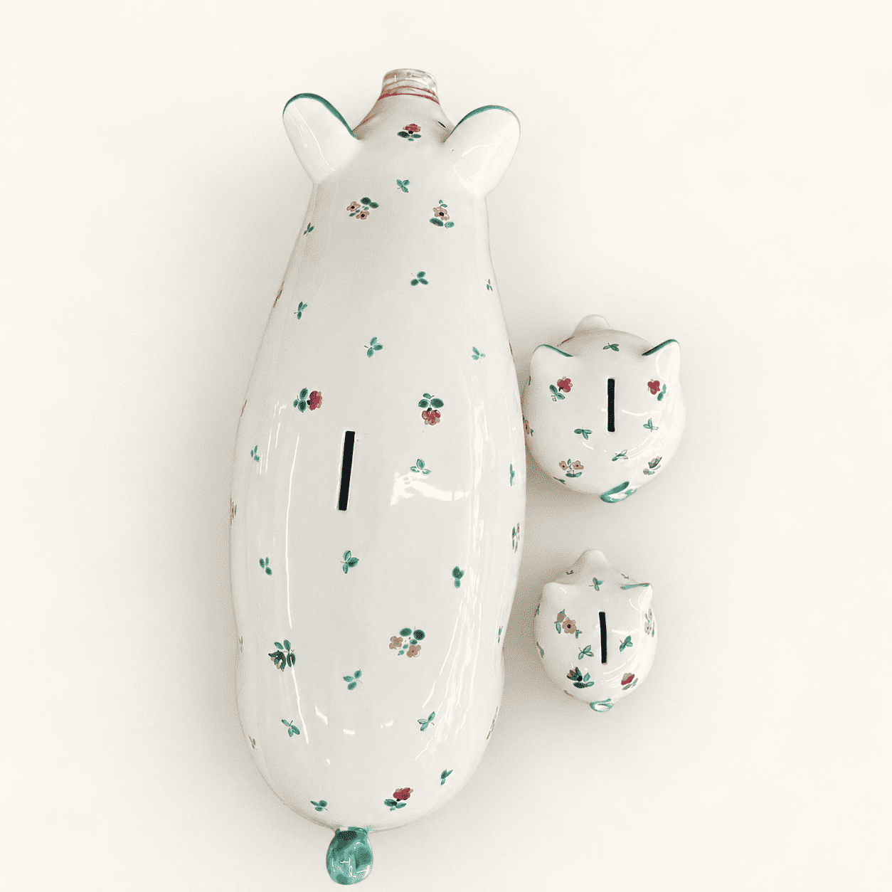 Top view of three Streublumen floral piggy banks showing coin slots on their backs