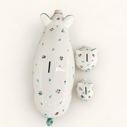 Top view of three Streublumen floral piggy banks showing coin slots on their backs