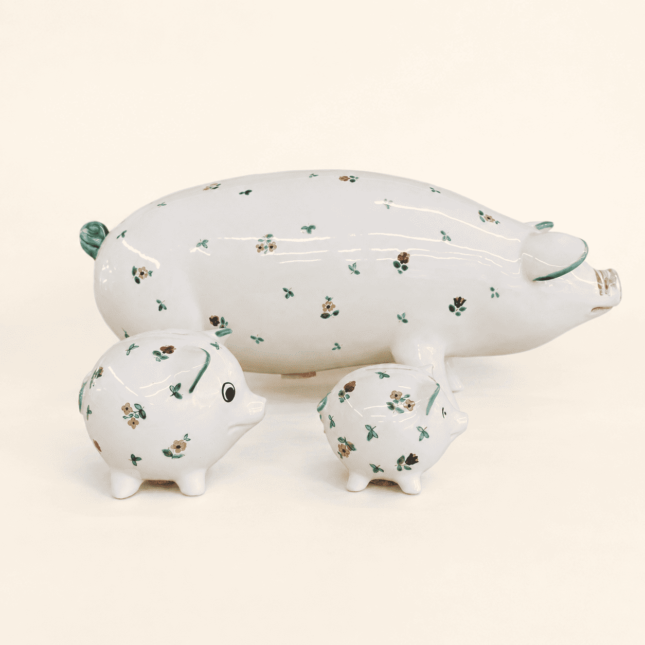 Three hand-painted Streublumen pig banks, large with two small, angled front