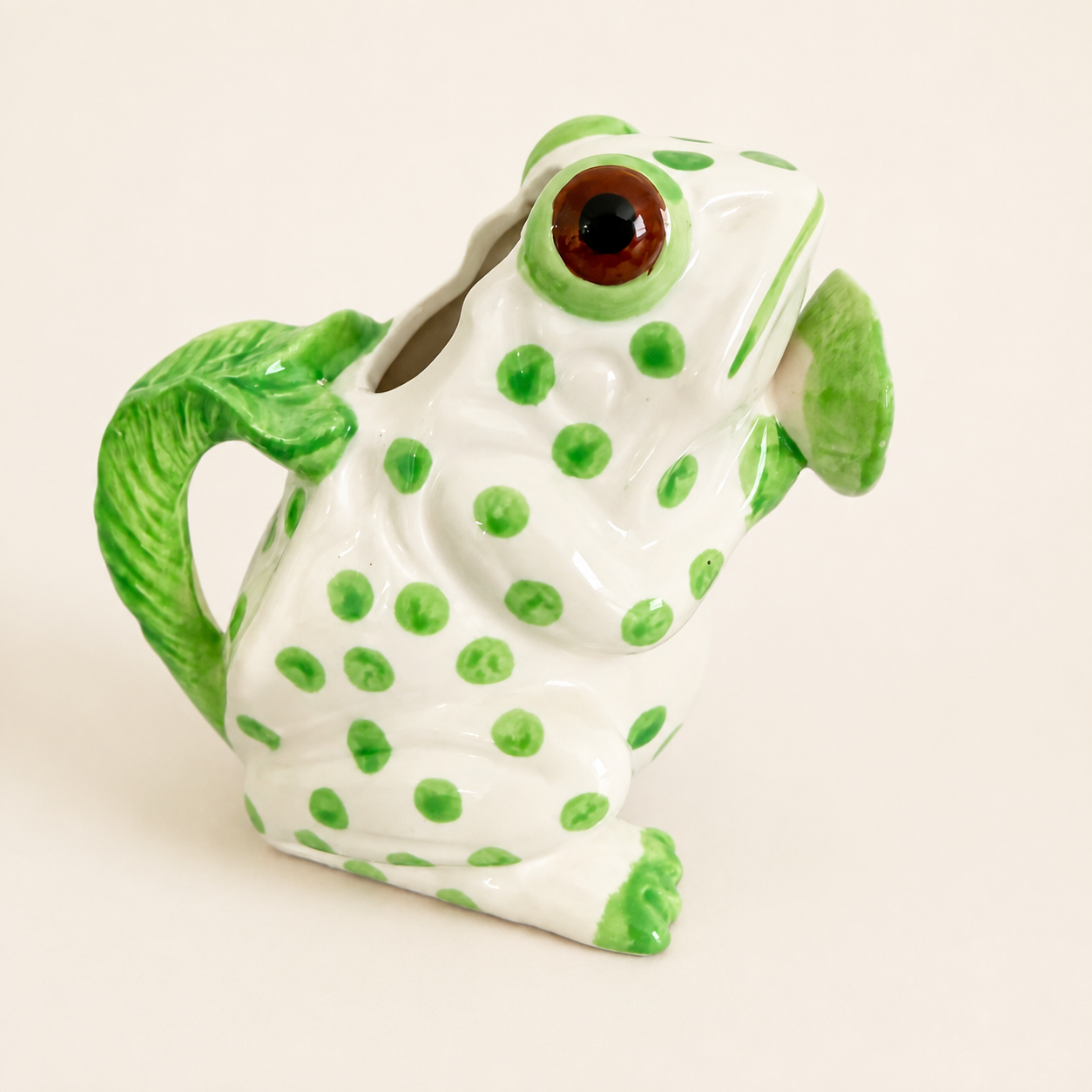 Hand-painted green polka-dot frog creamer, front view with amber eyes