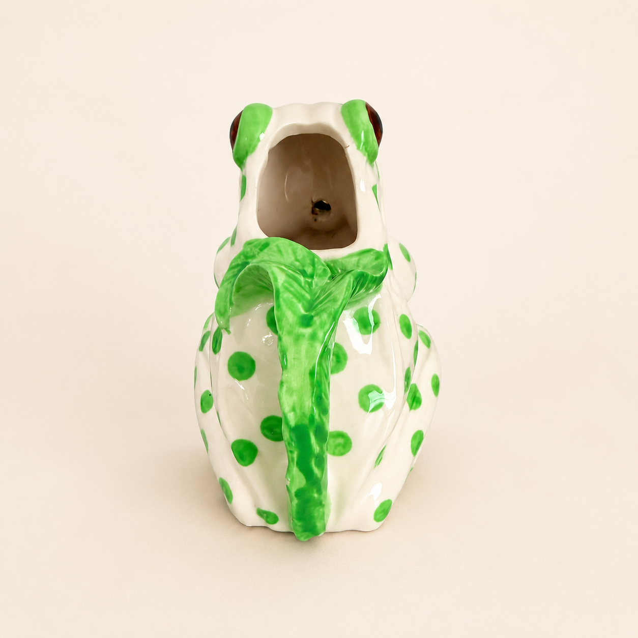 Back of frog creamer showing pour opening and leaf handle
