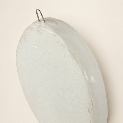 Angled back view of ceramic floral plaque with hanger