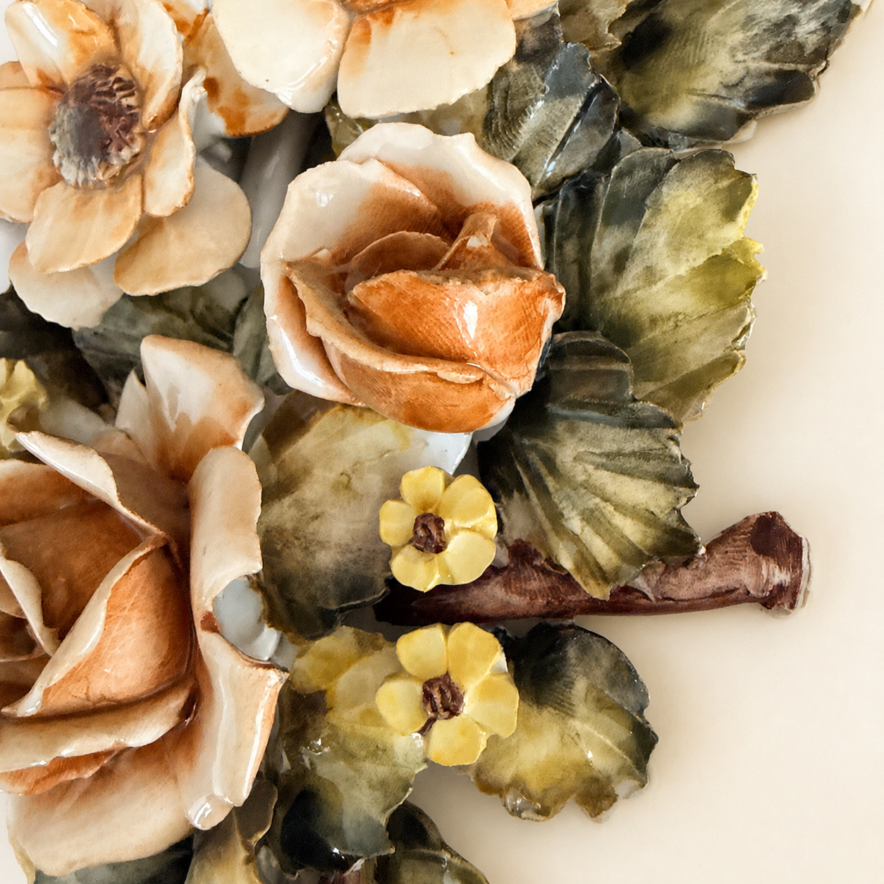 Close-up of applied ceramic rosebud and yellow blossoms