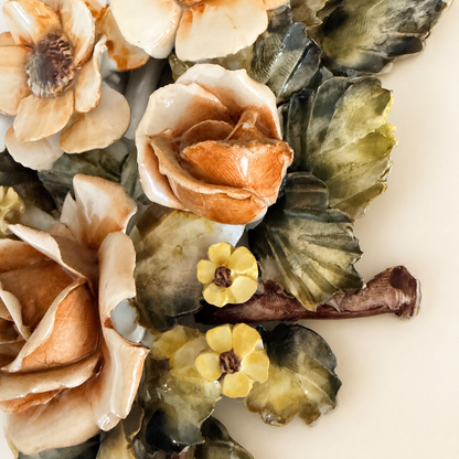 Close-up of applied ceramic rosebud and yellow blossoms