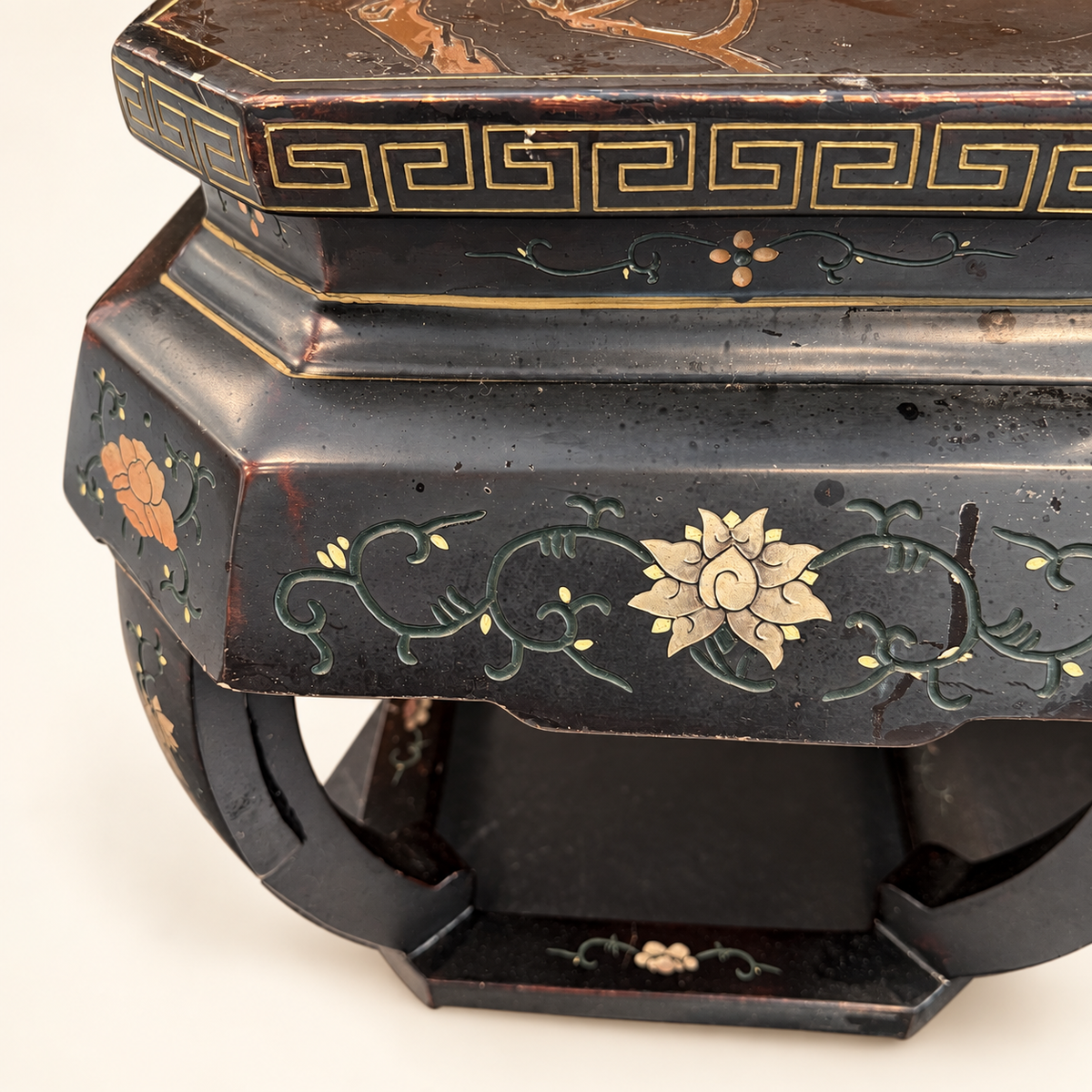 Trailing polychrome vines on black lacquer stool panel