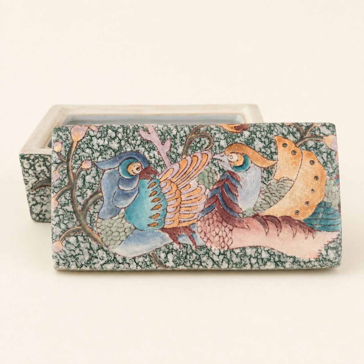 Front of porcelain box with raised flower enamel on green sponged ground