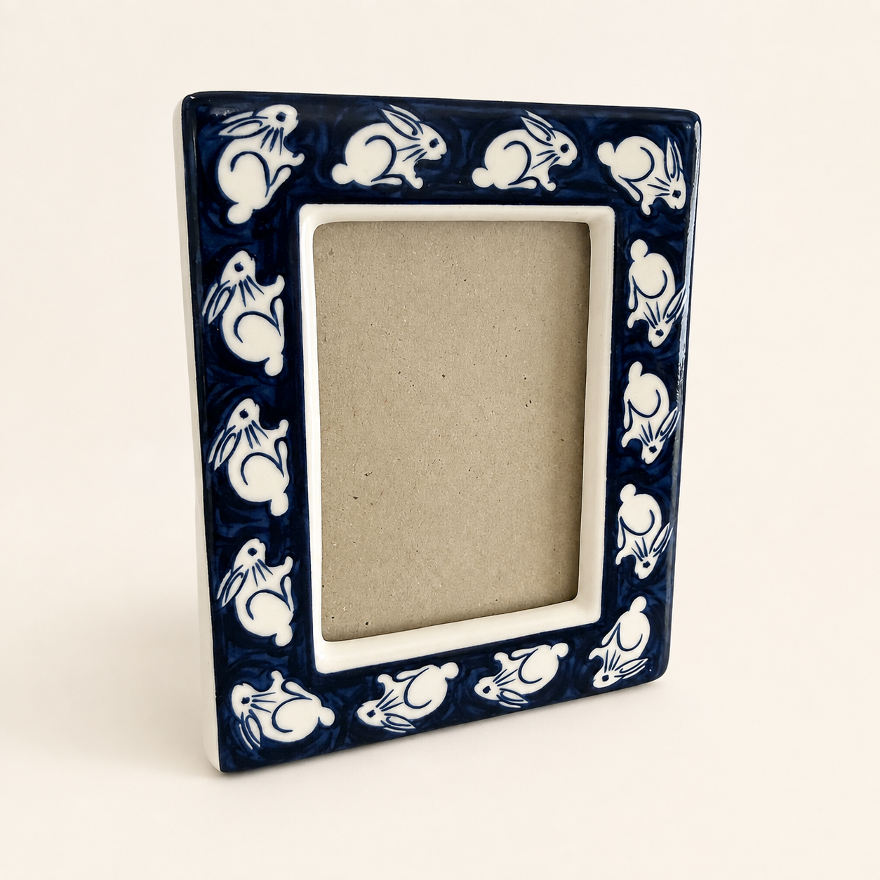Cobalt blue and white ceramic photo frame with white rabbit border, front view