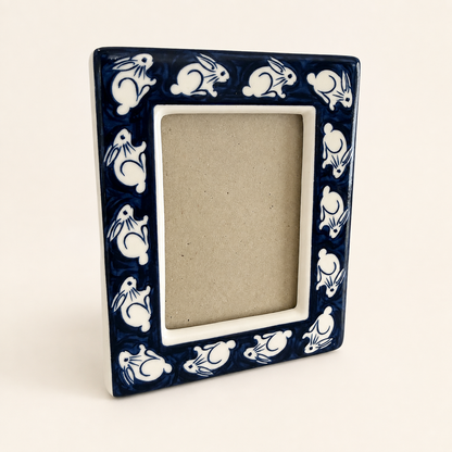 Cobalt blue and white ceramic photo frame with white rabbit border, front view