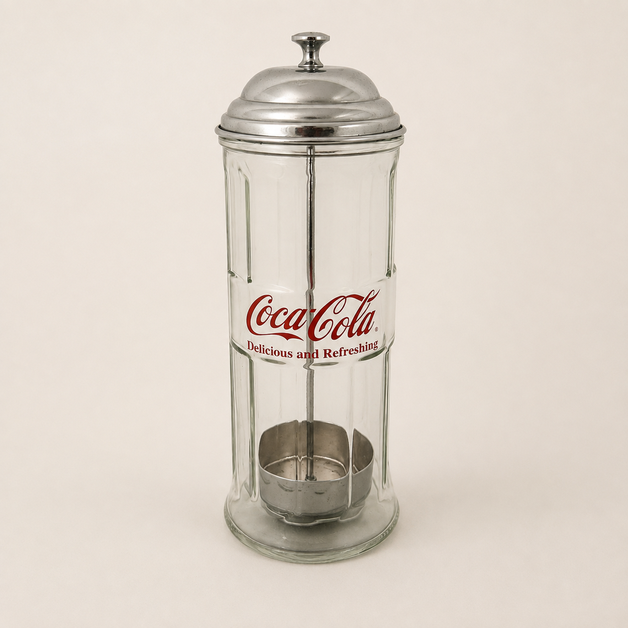 Coca-Cola glass straw dispenser with domed metal lid and red logo, front view