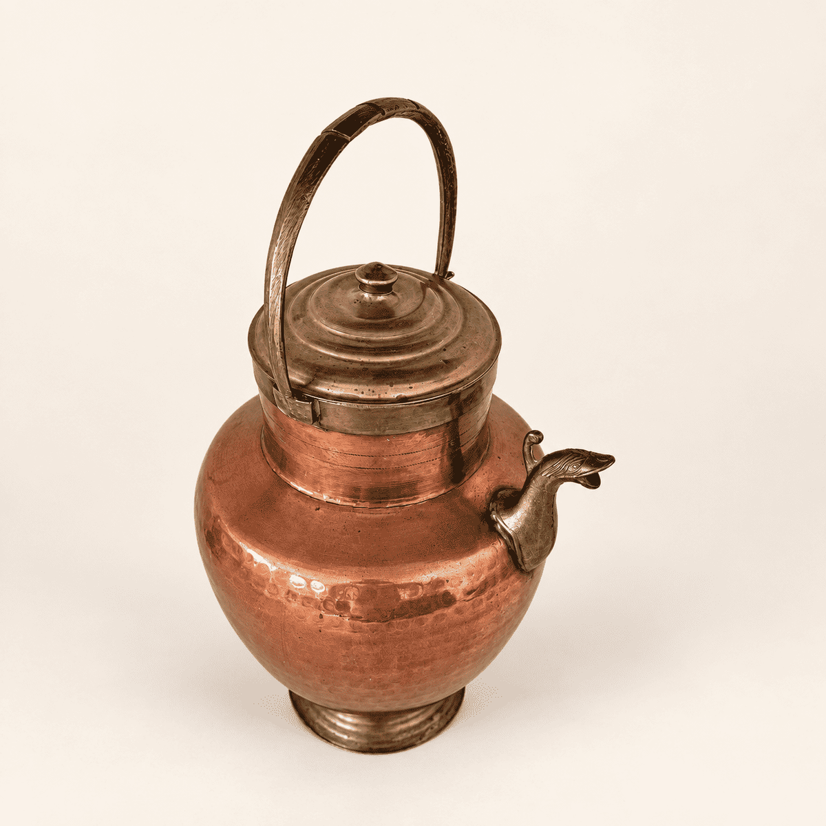 Hand-hammered copper belly and ribbed brass foot of the ewer